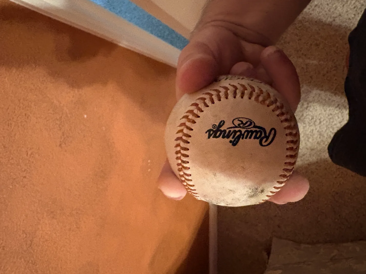 A top view of a split-finger grip, two fingers spread apart over the ball.